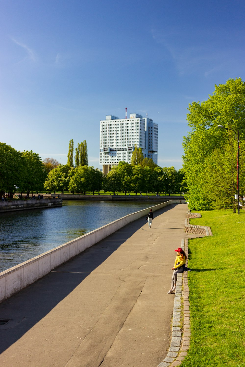 a person sitting on a bench next to a body of water