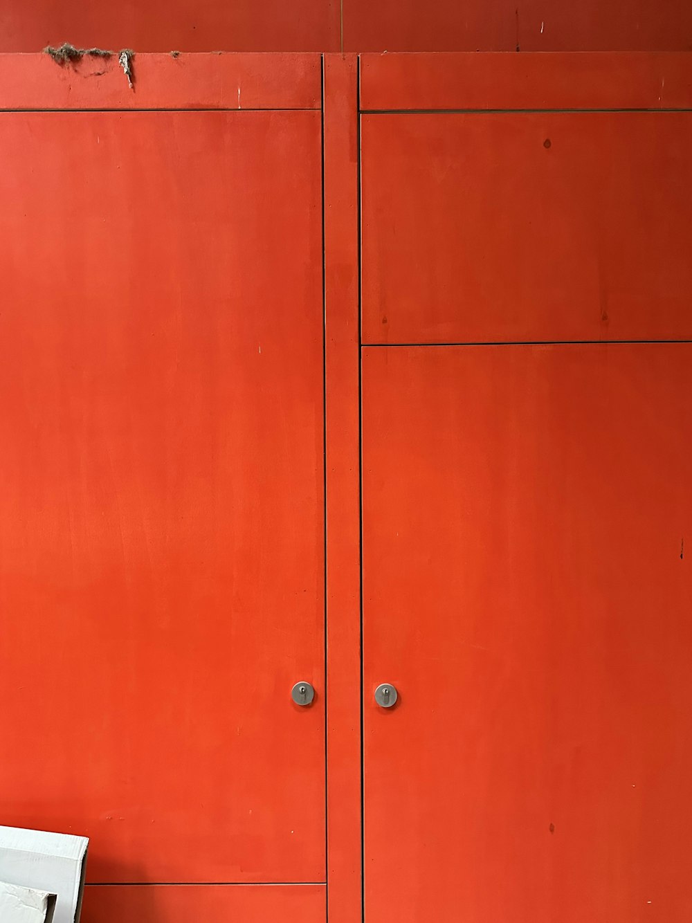 a red wall with a white toilet in front of it