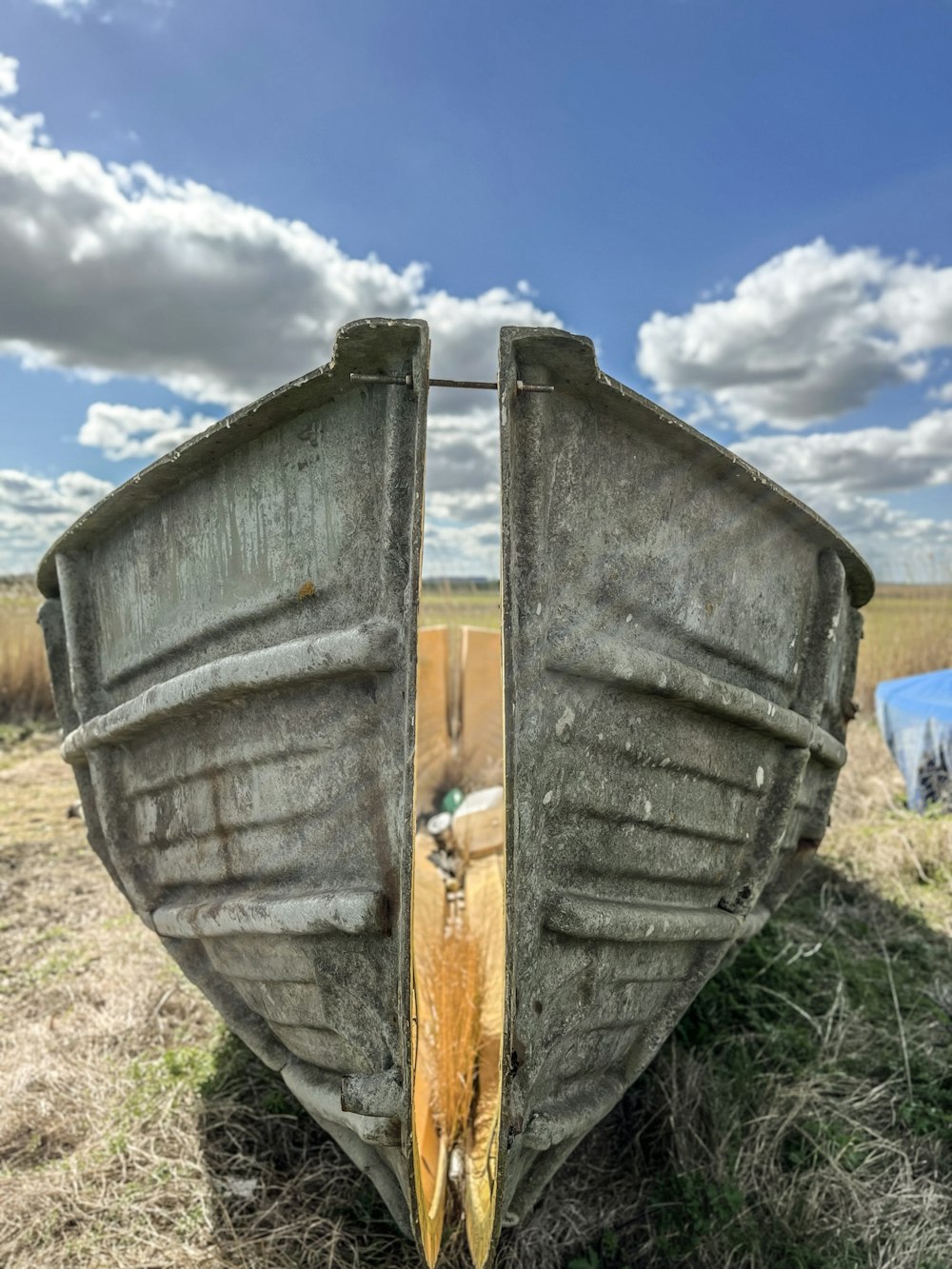 a boat sitting on top of a dry grass field