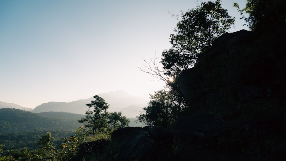 a view of a mountain with trees and mountains in the background