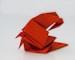 a red origami bird sitting on top of a table