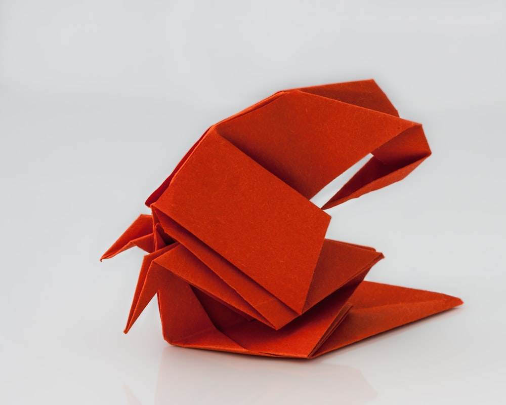 a red origami bird sitting on top of a table