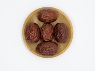 A close-up of various premium dates displayed on a wooden platter.