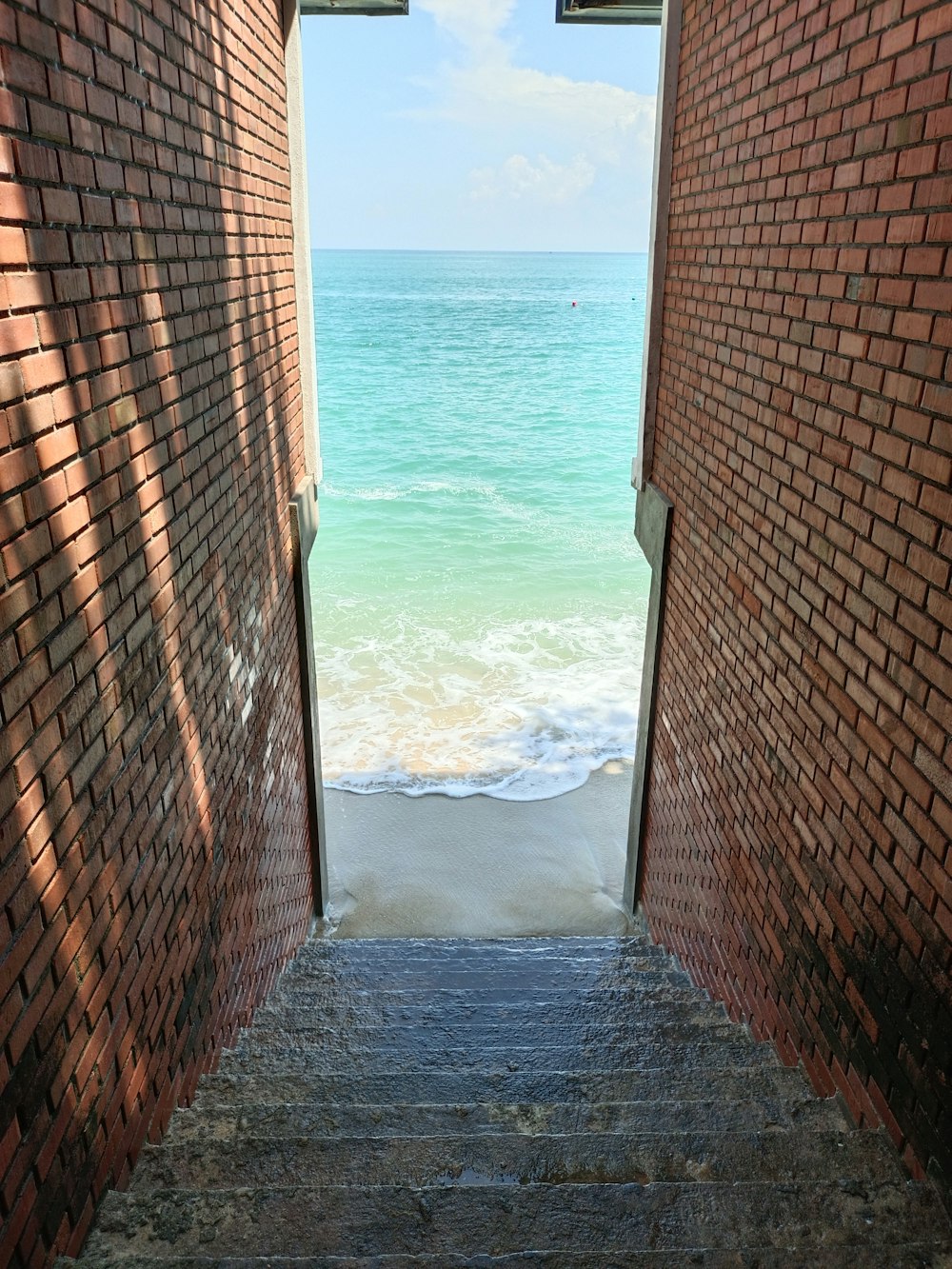 an open door leading to a beach with a view of the ocean