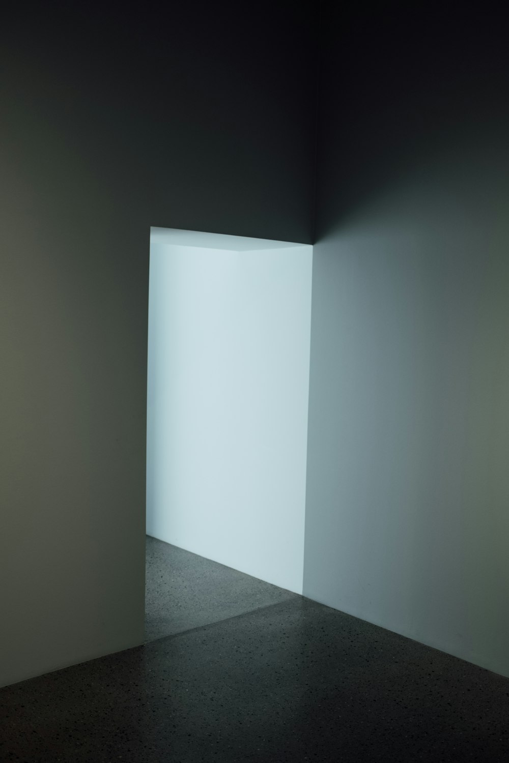 an empty room with a light coming through the wall