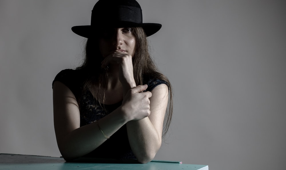 a woman wearing a black hat sitting at a table