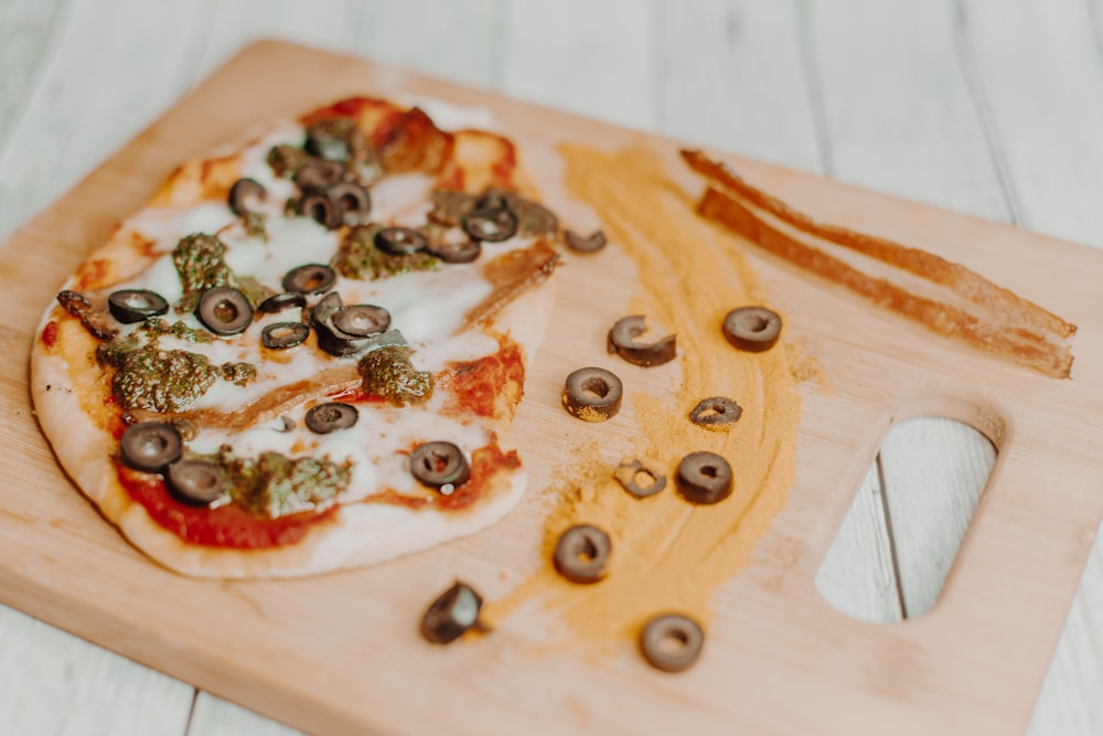 a pizza sitting on top of a wooden cutting board