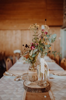 Rustic dinner table adorned with natural flower arrangements in pastel greens.