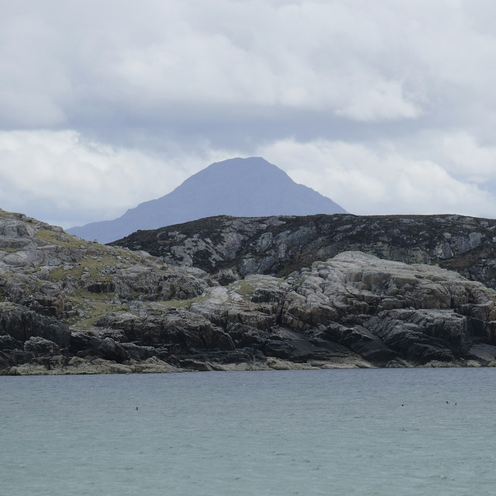 a large body of water with a mountain in the background