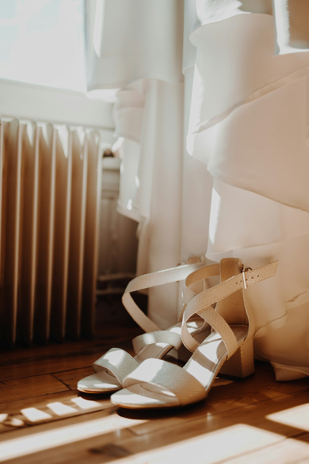 a pair of shoes sitting on the floor next to a radiator
