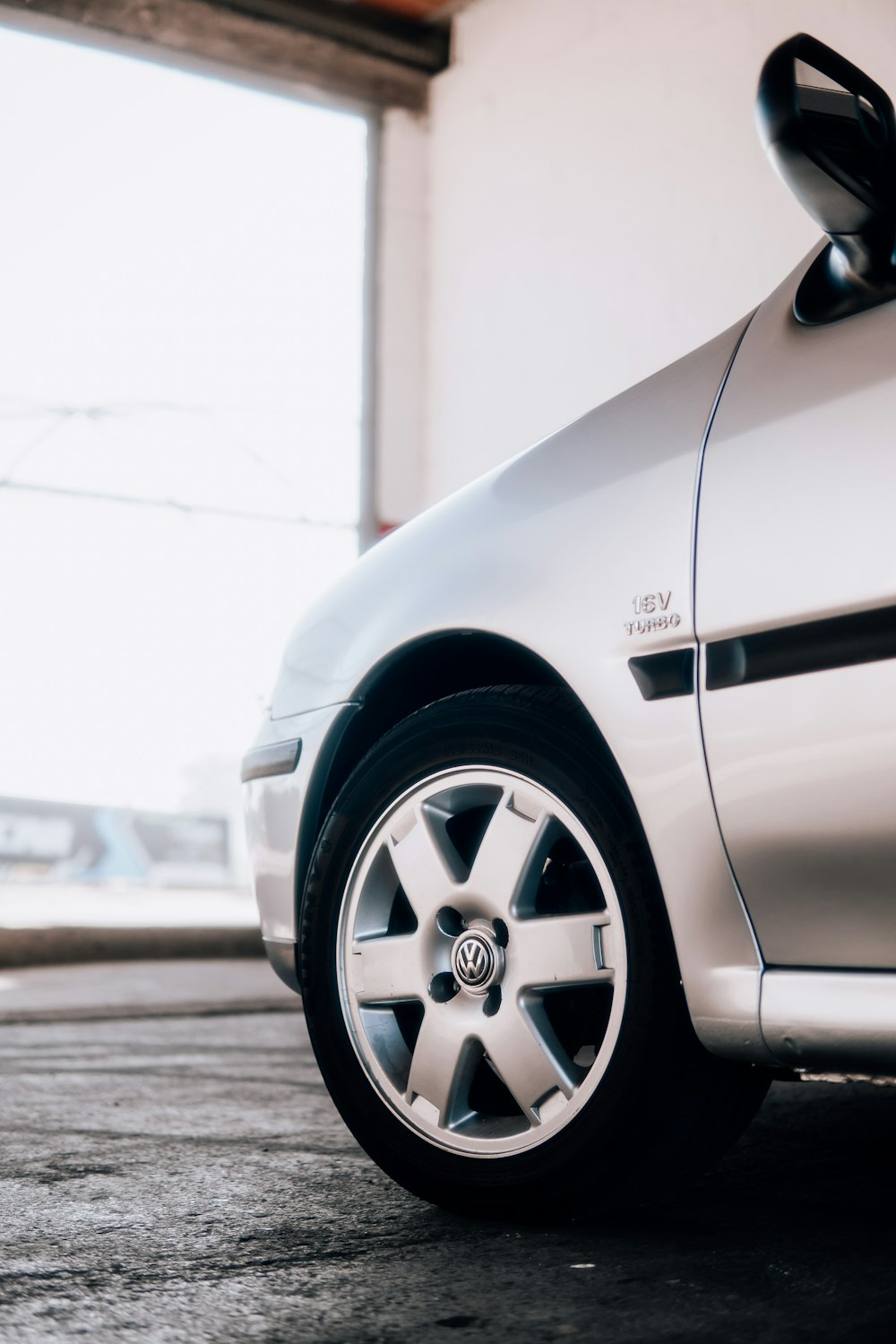 a white car parked in a garage next to a window