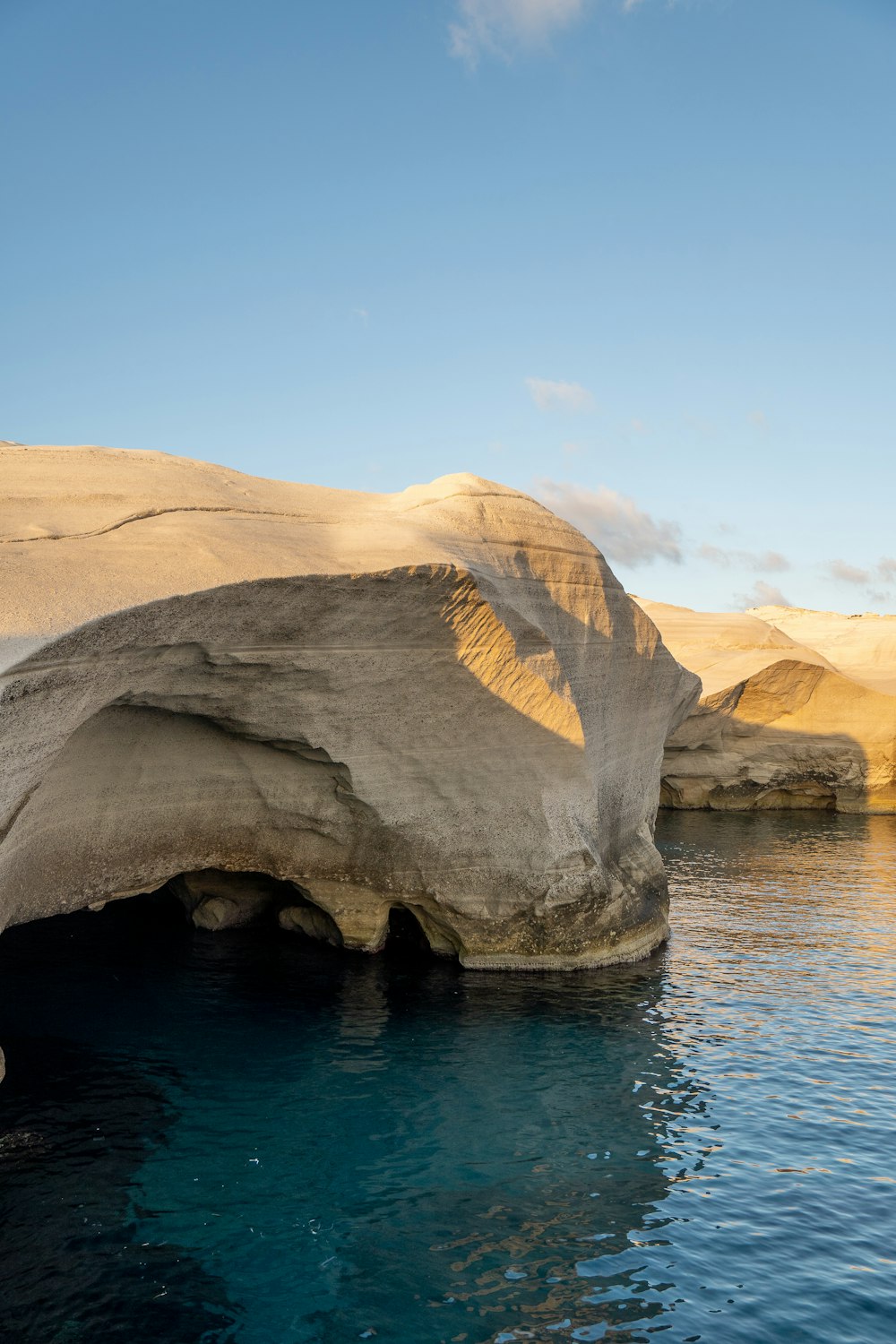 a large rock sticking out of a body of water