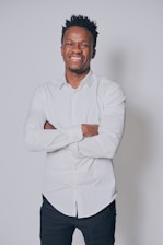 A happy person wearing a bold graphic tee, standing against a clean, neutral background.