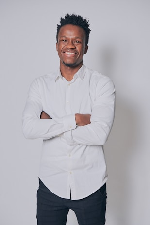 A happy person wearing a bold graphic tee, standing against a clean, neutral background.