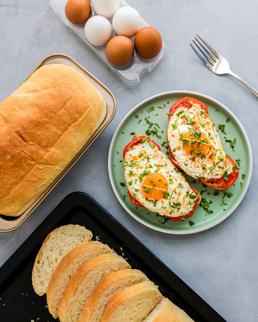 a plate of eggs and a loaf of bread on a table