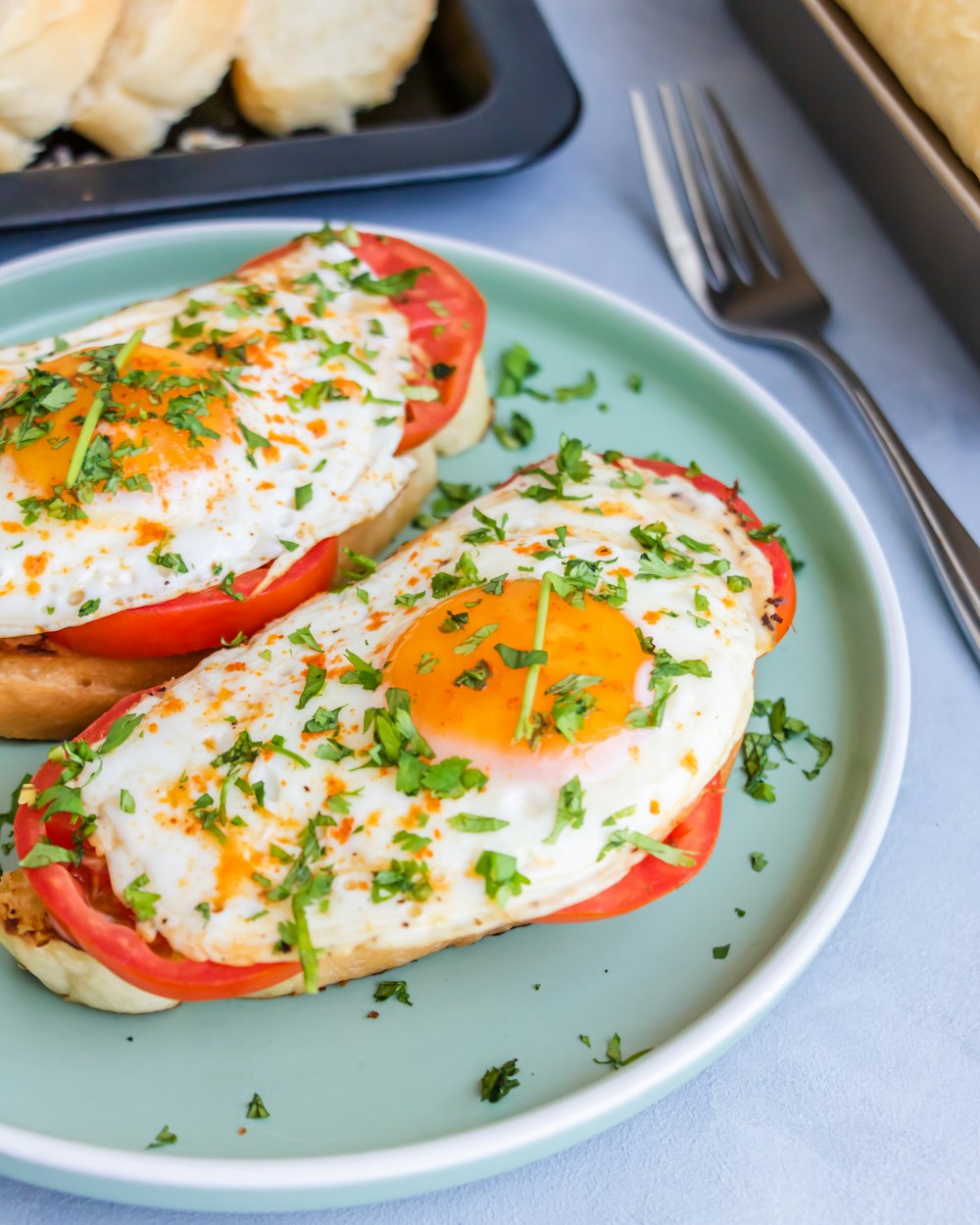 a plate with two eggs and tomatoes on it