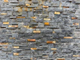 Finished stone wall featuring a mix of granite and marble tiles.