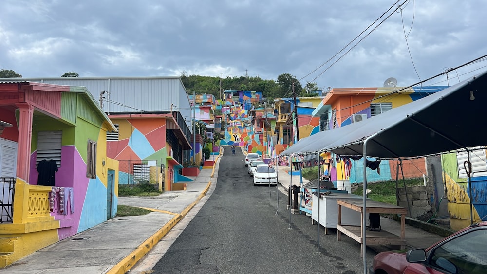 a street lined with colorful houses and parked cars