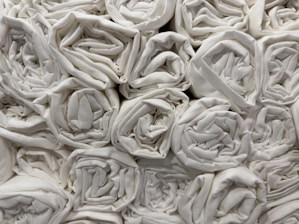 A collection of neatly rolled white towels stacked closely together in an orderly fashion.