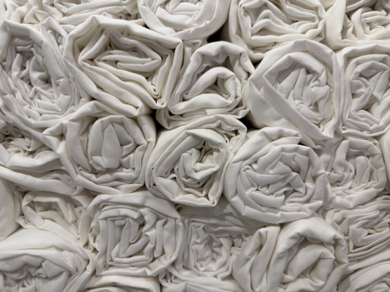 A collection of neatly rolled white towels stacked closely together in an orderly fashion.