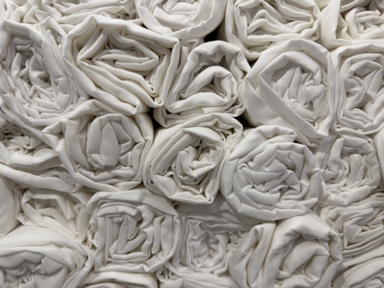A collection of neatly rolled white towels stacked closely together in an orderly fashion.