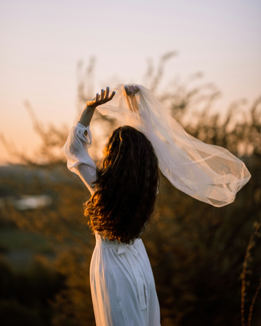 a woman wearing a white dress and a white shawl