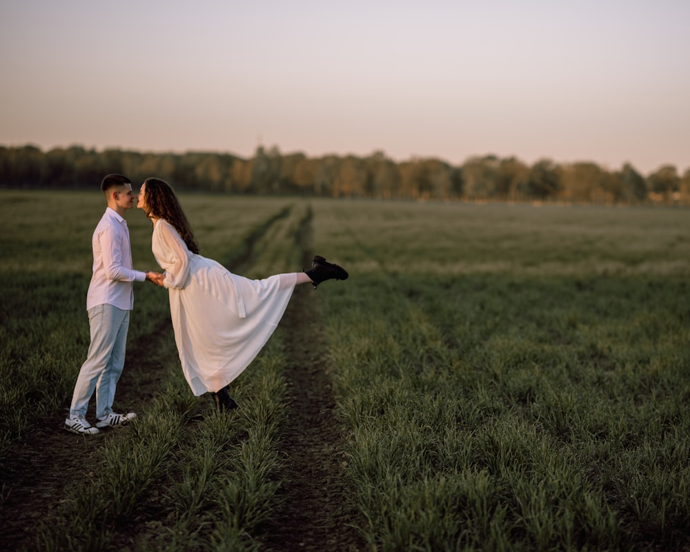a man and a woman are standing in a field