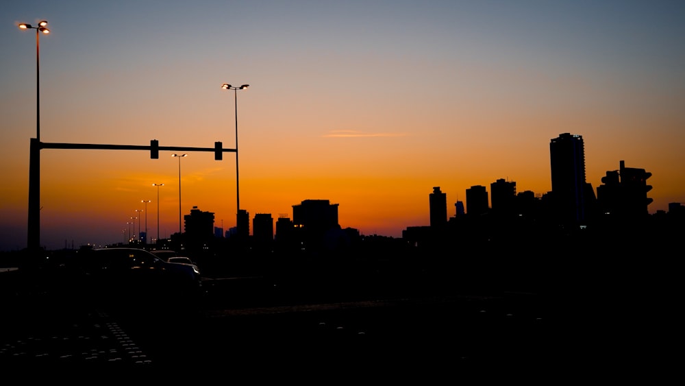 the sun is setting over a city with tall buildings