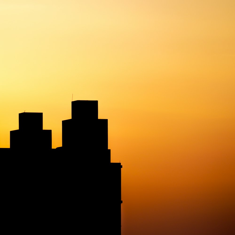 a plane flying in the sky at sunset