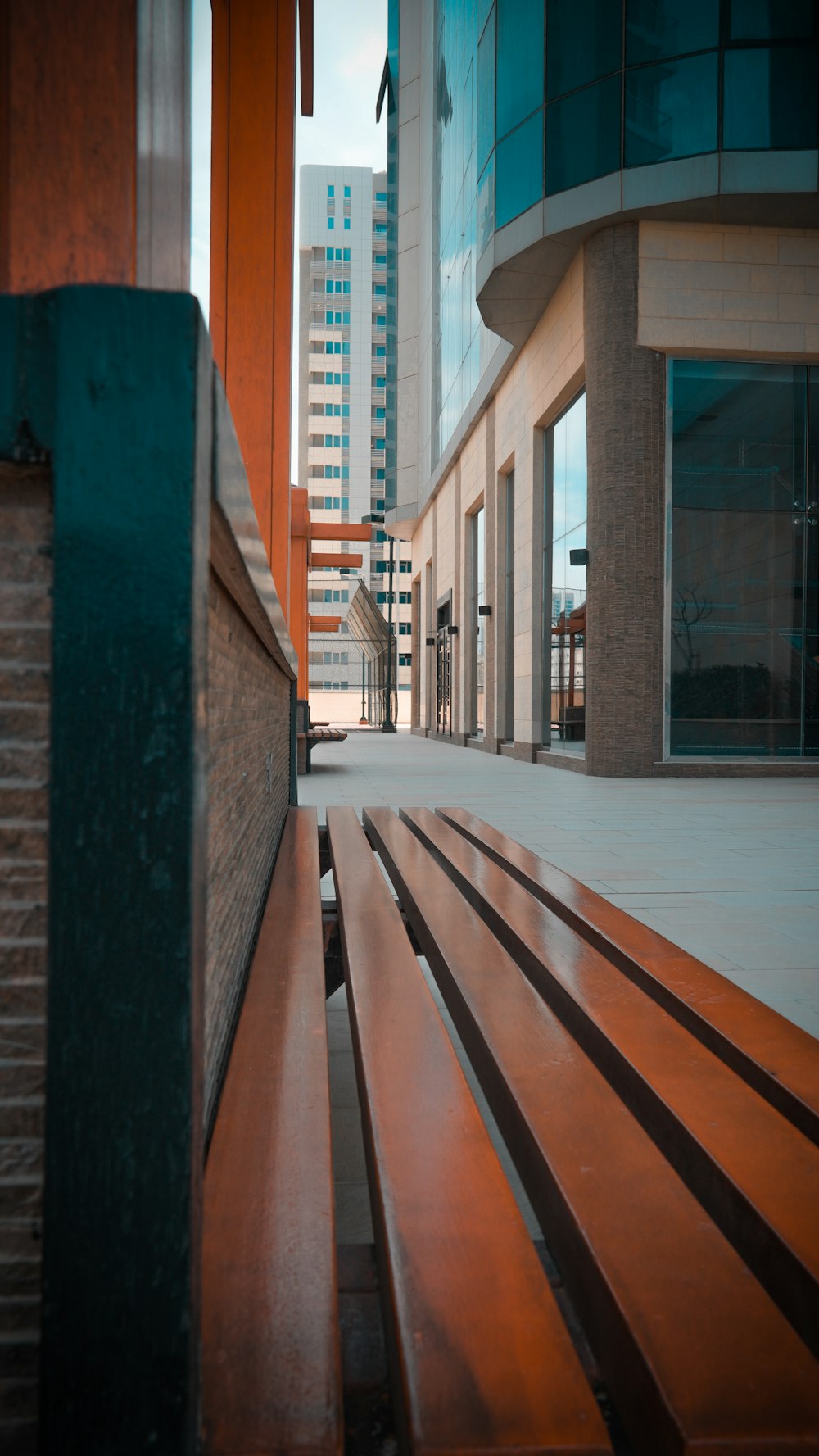 a wooden bench sitting in front of a tall building