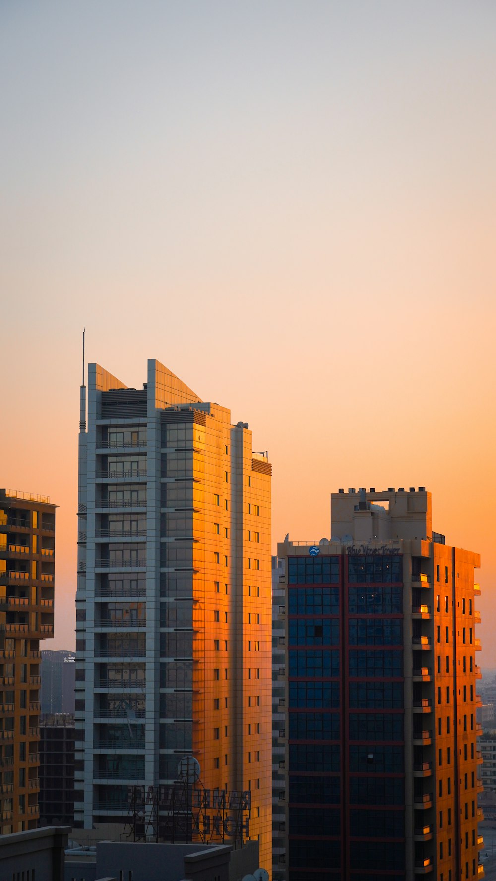 a city skyline with tall buildings at sunset