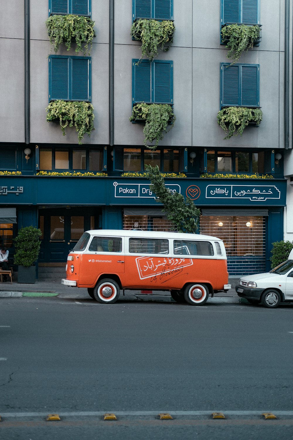 an orange and white van parked in front of a building