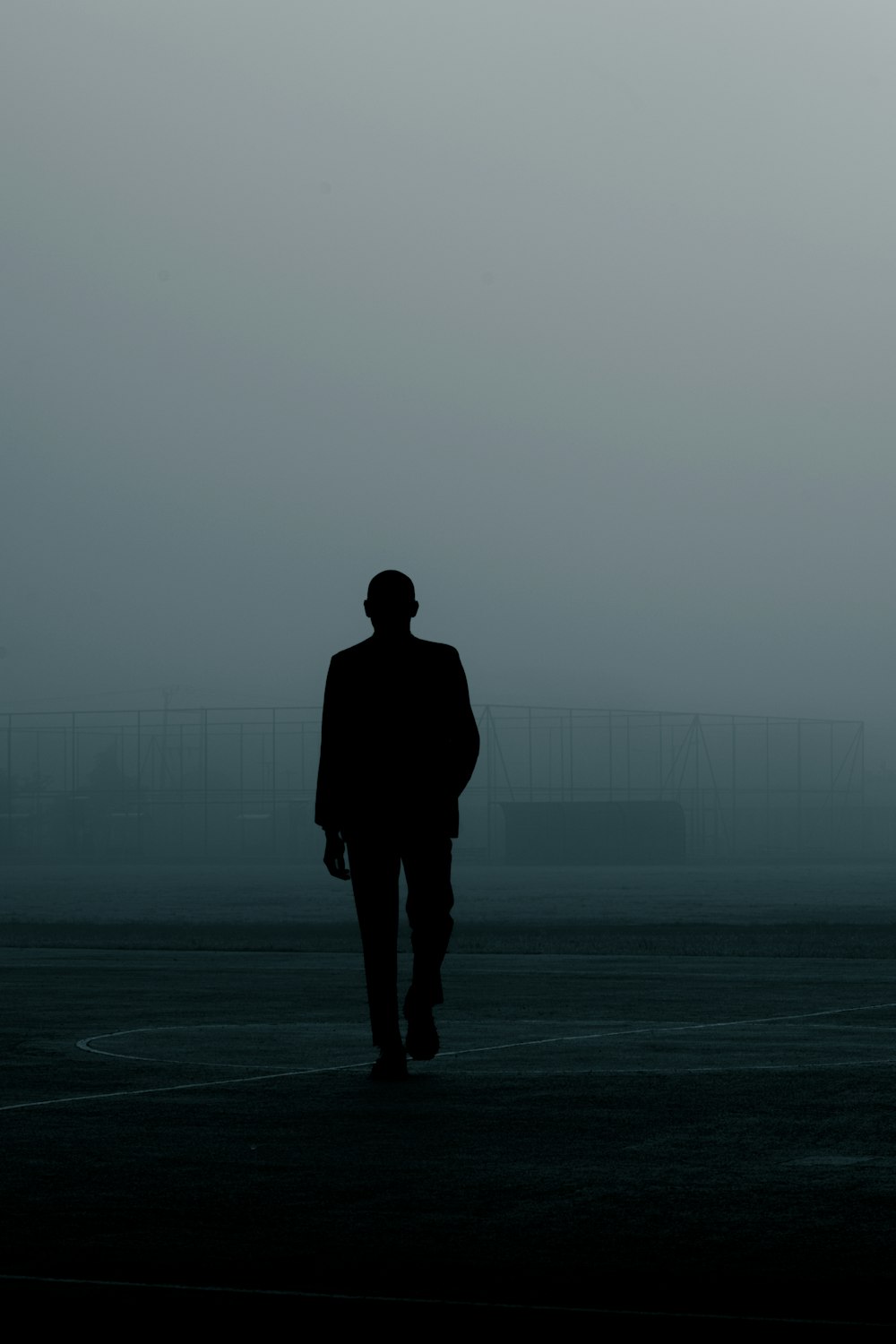 a man in a suit walking in a parking lot
