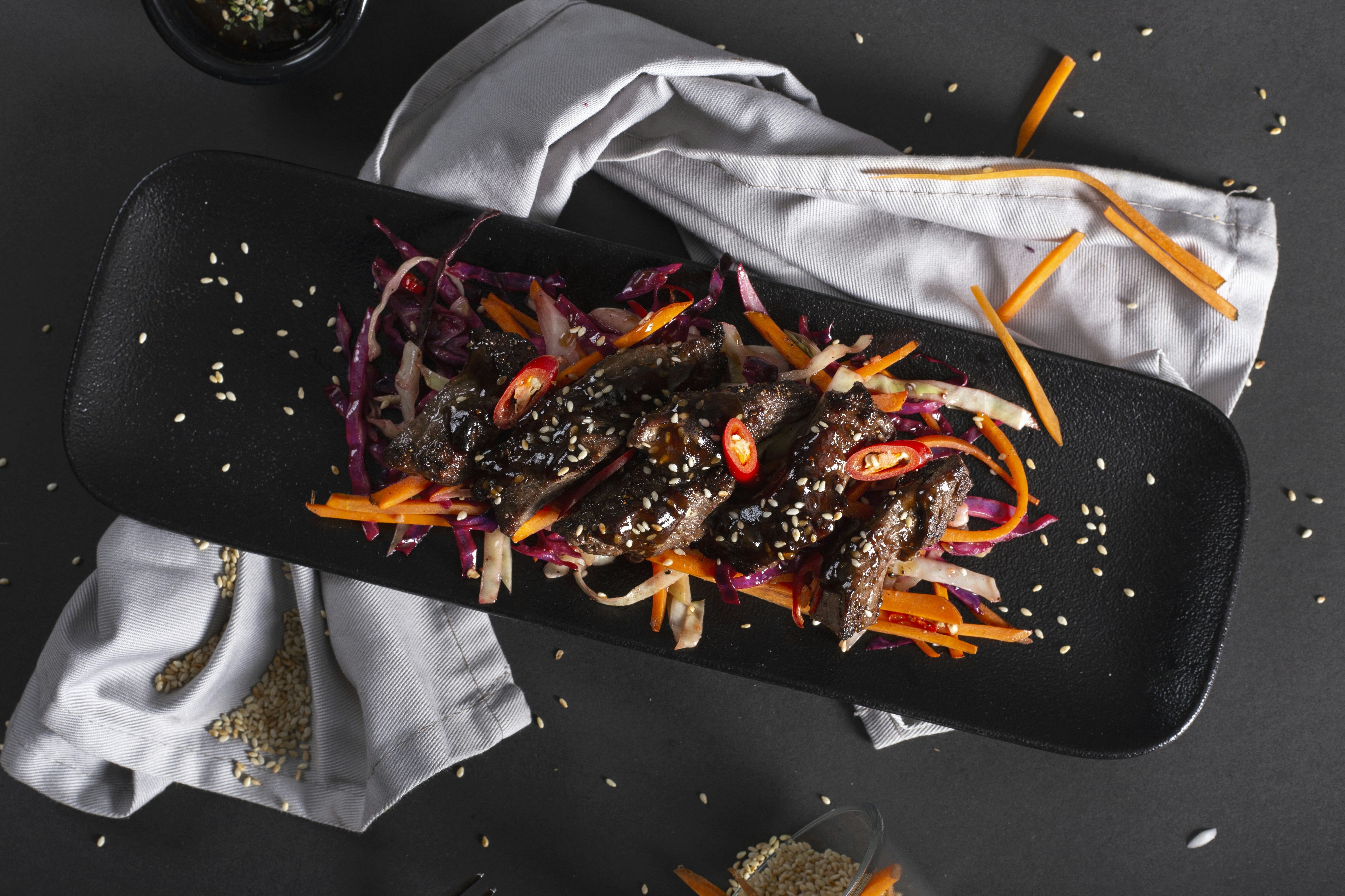 a black tray topped with meat and veggies