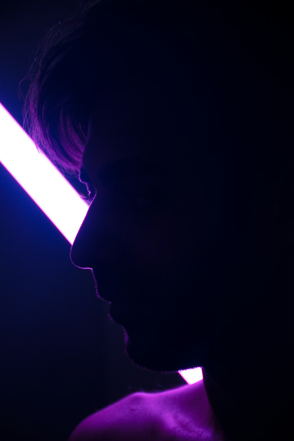 a silhouette of a man with a purple light behind him