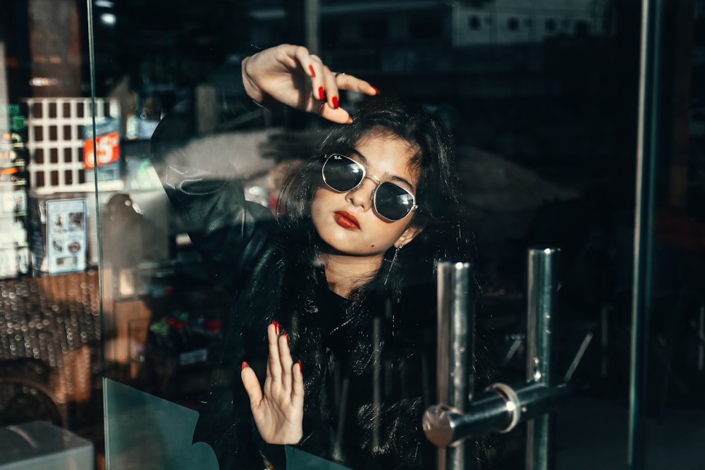 a woman with dark hair wearing sunglasses and a black jacket