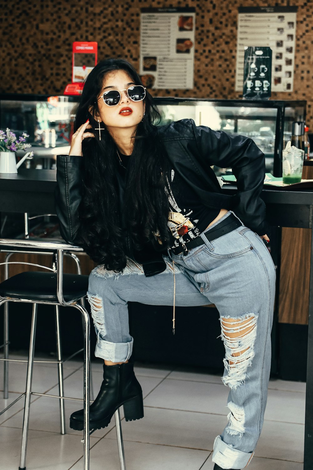 a woman sitting on a stool in a restaurant