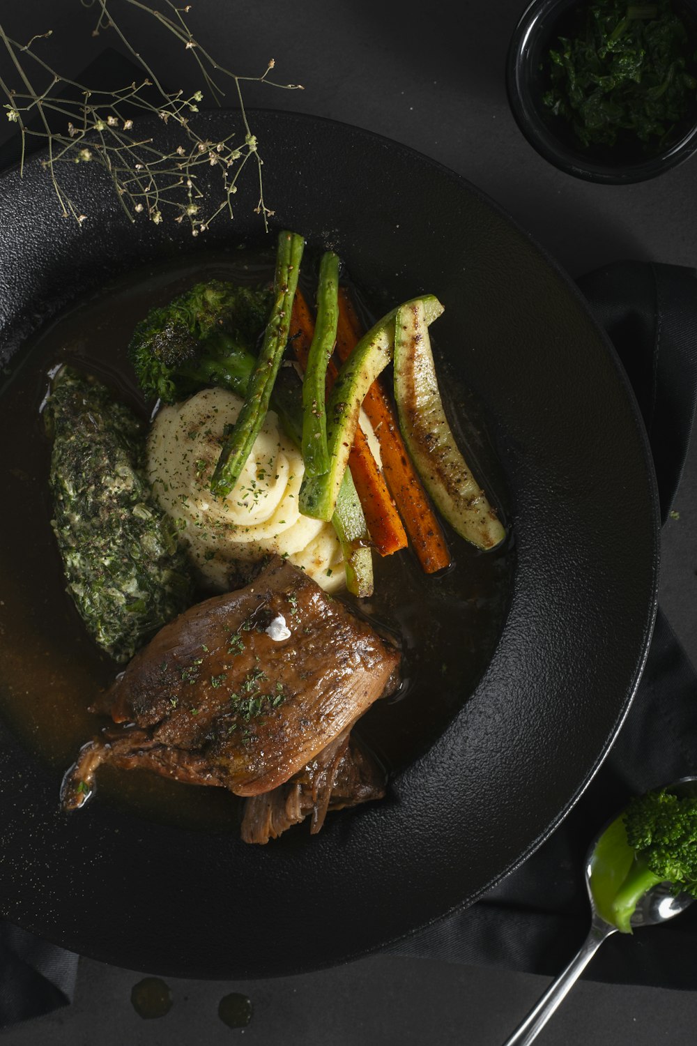 a plate of food with meat, vegetables, and broccoli