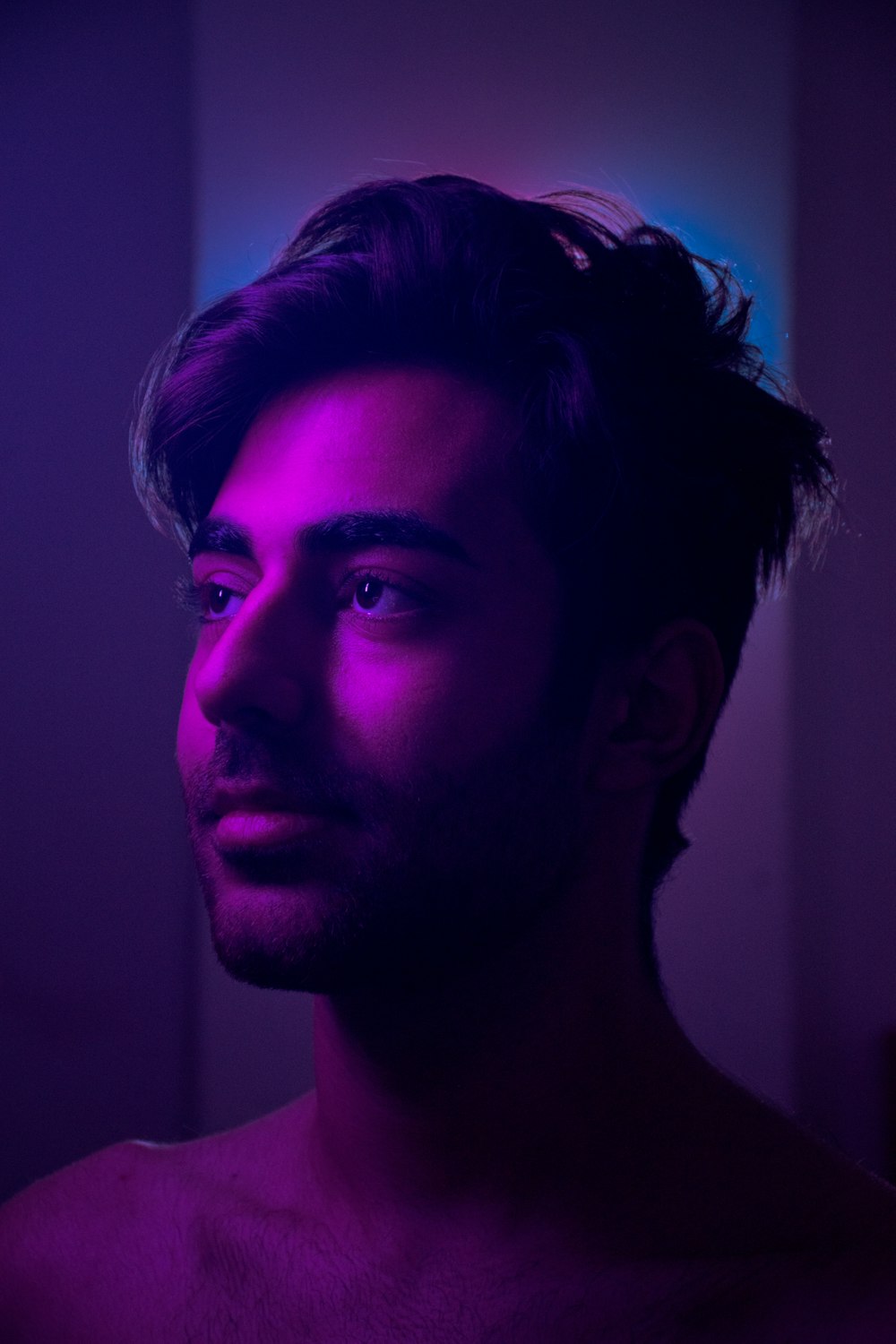 a man in a dark room with a purple light