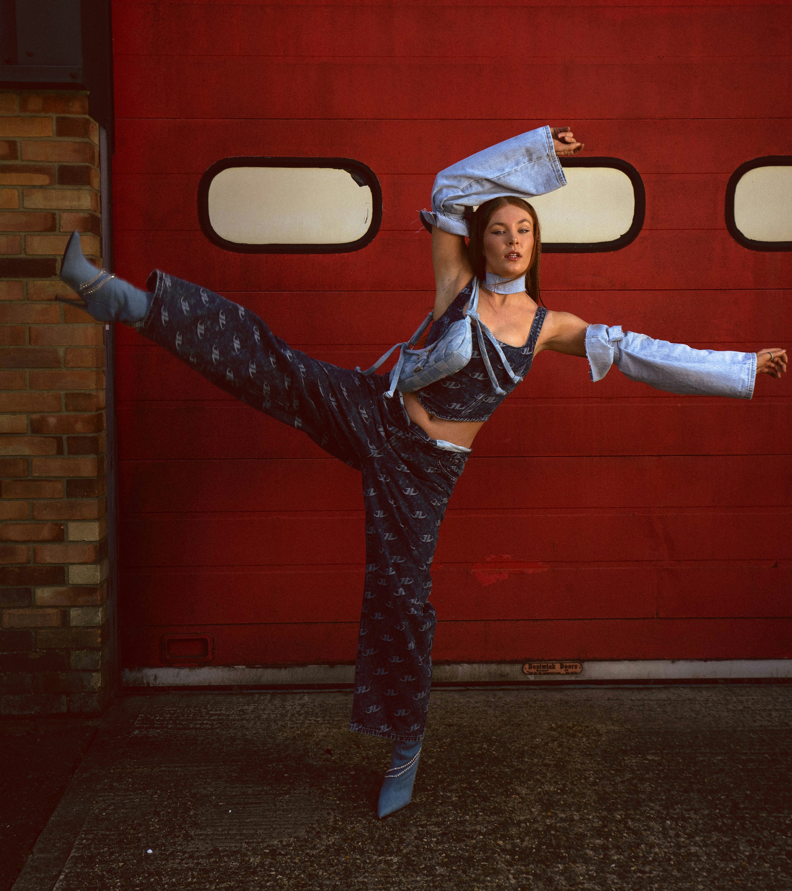 a woman is doing a dance move in front of a red door