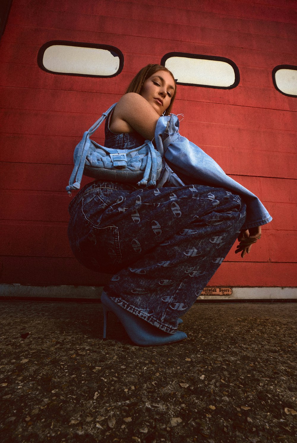 a woman is sitting on the ground in front of a red door