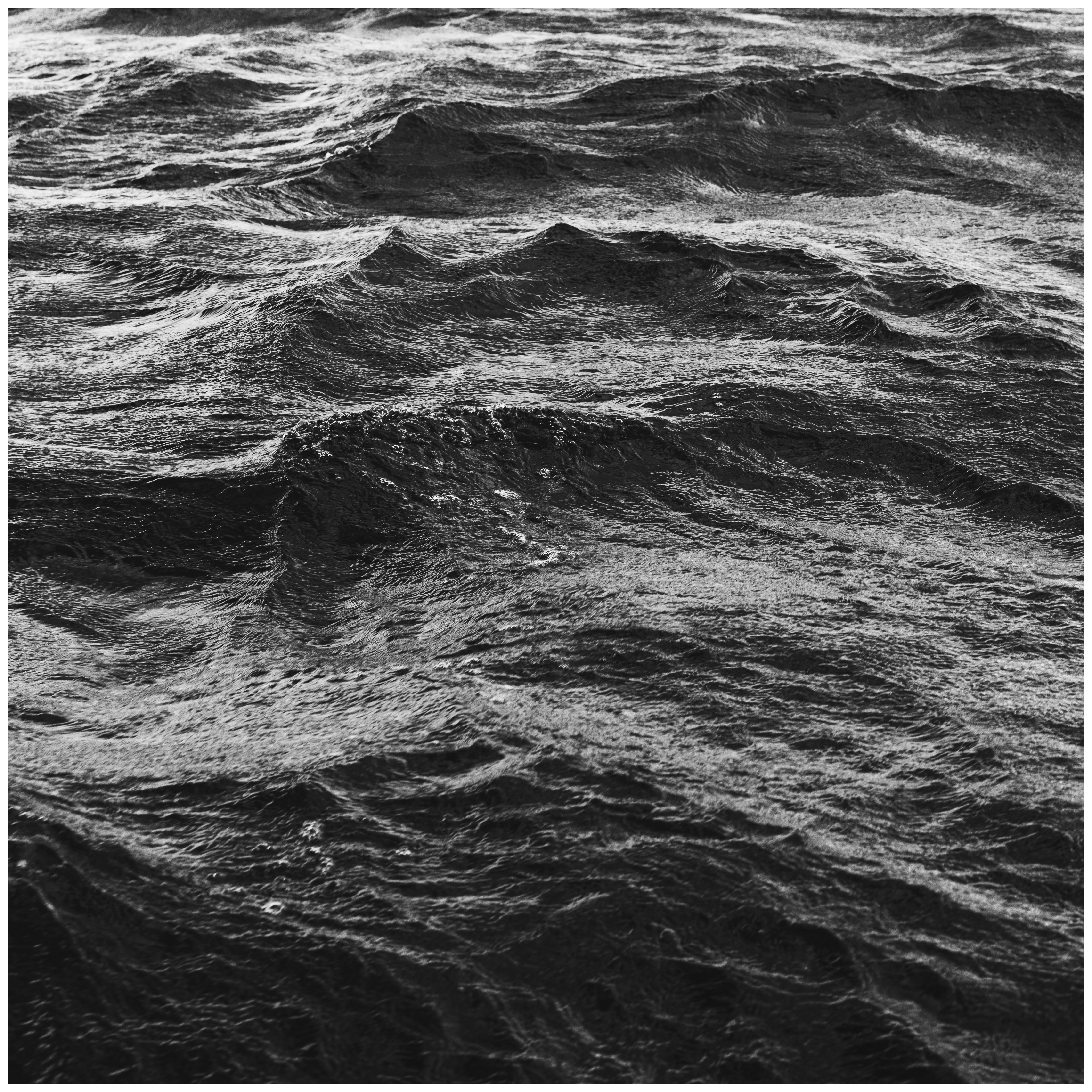 Une photo en noir et blanc des vagues dans l’océan