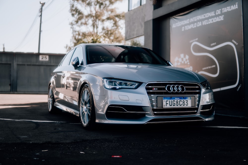 a silver car parked in front of a building