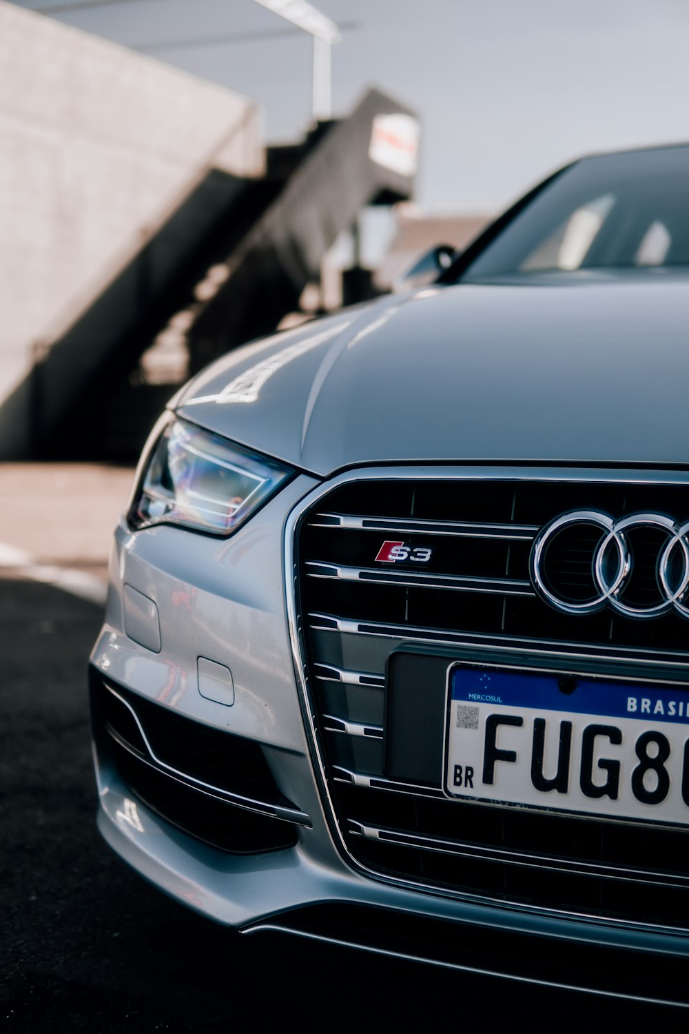 the front of a silver car parked in a parking lot