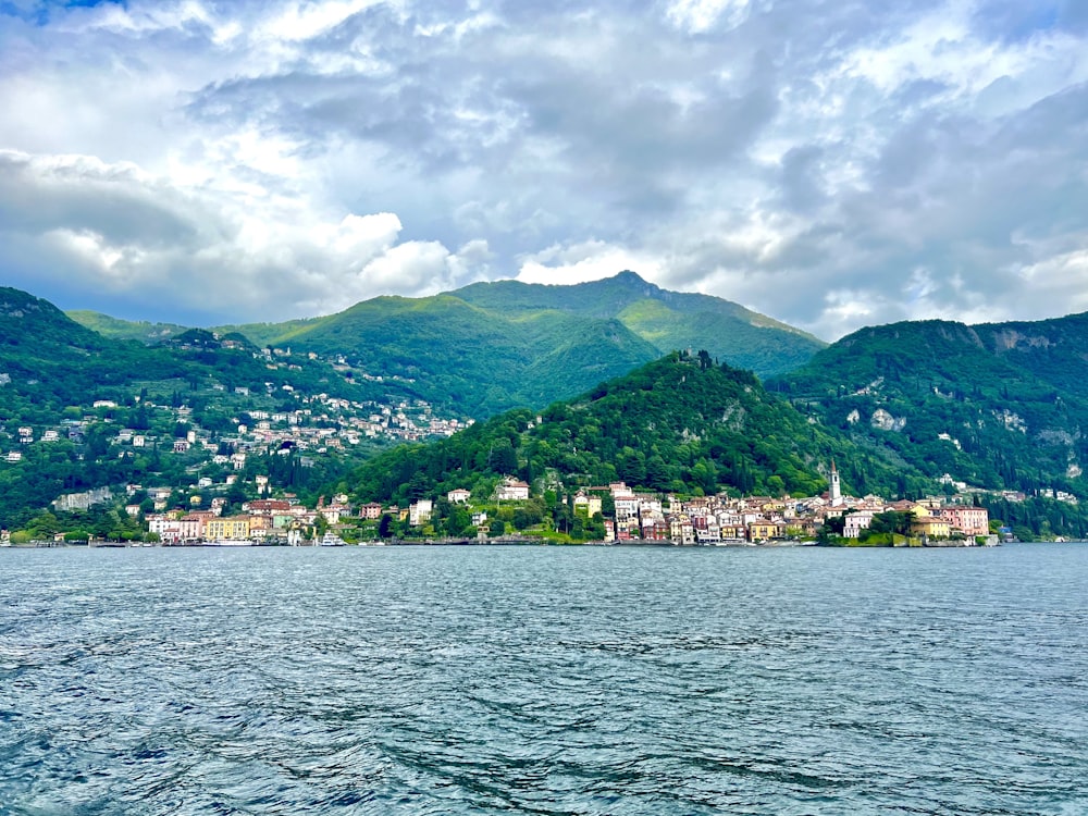 a body of water with a small town on a hill in the background