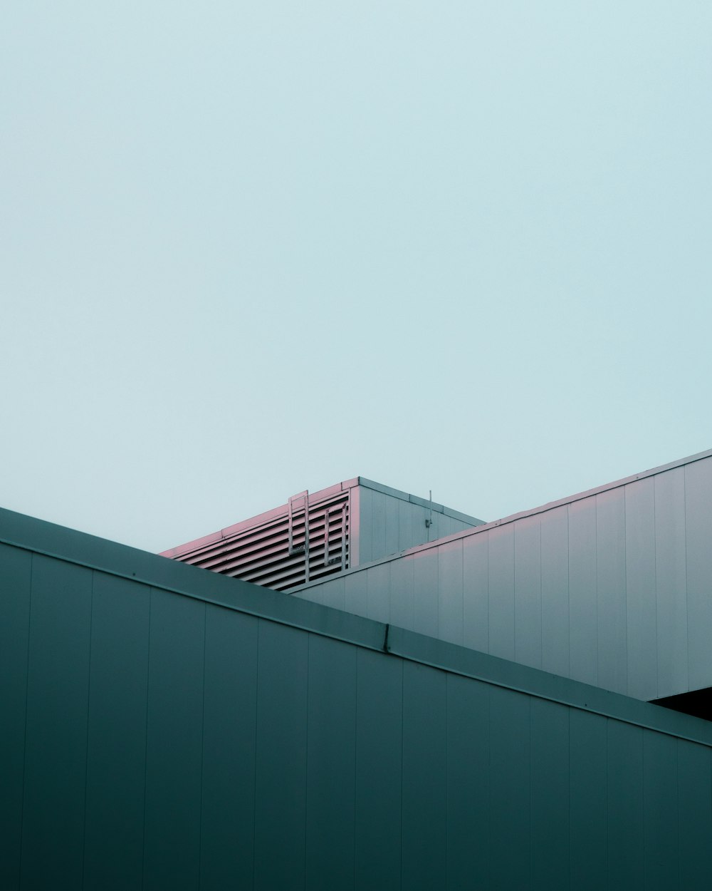 an airplane flying over a building with a sky background