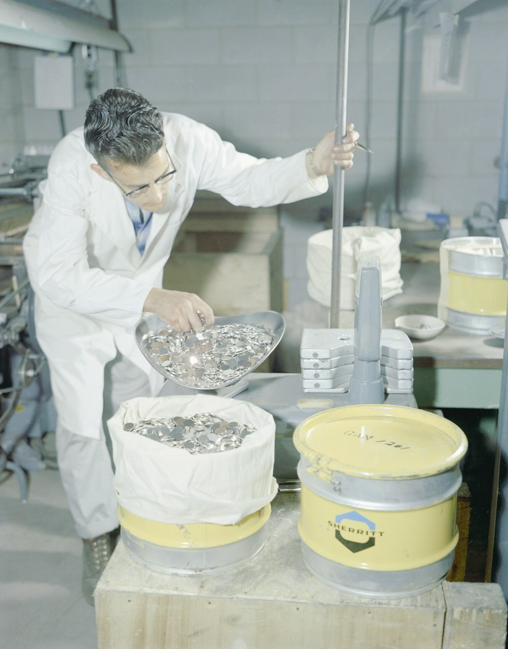 a man in a white lab coat working on a cake