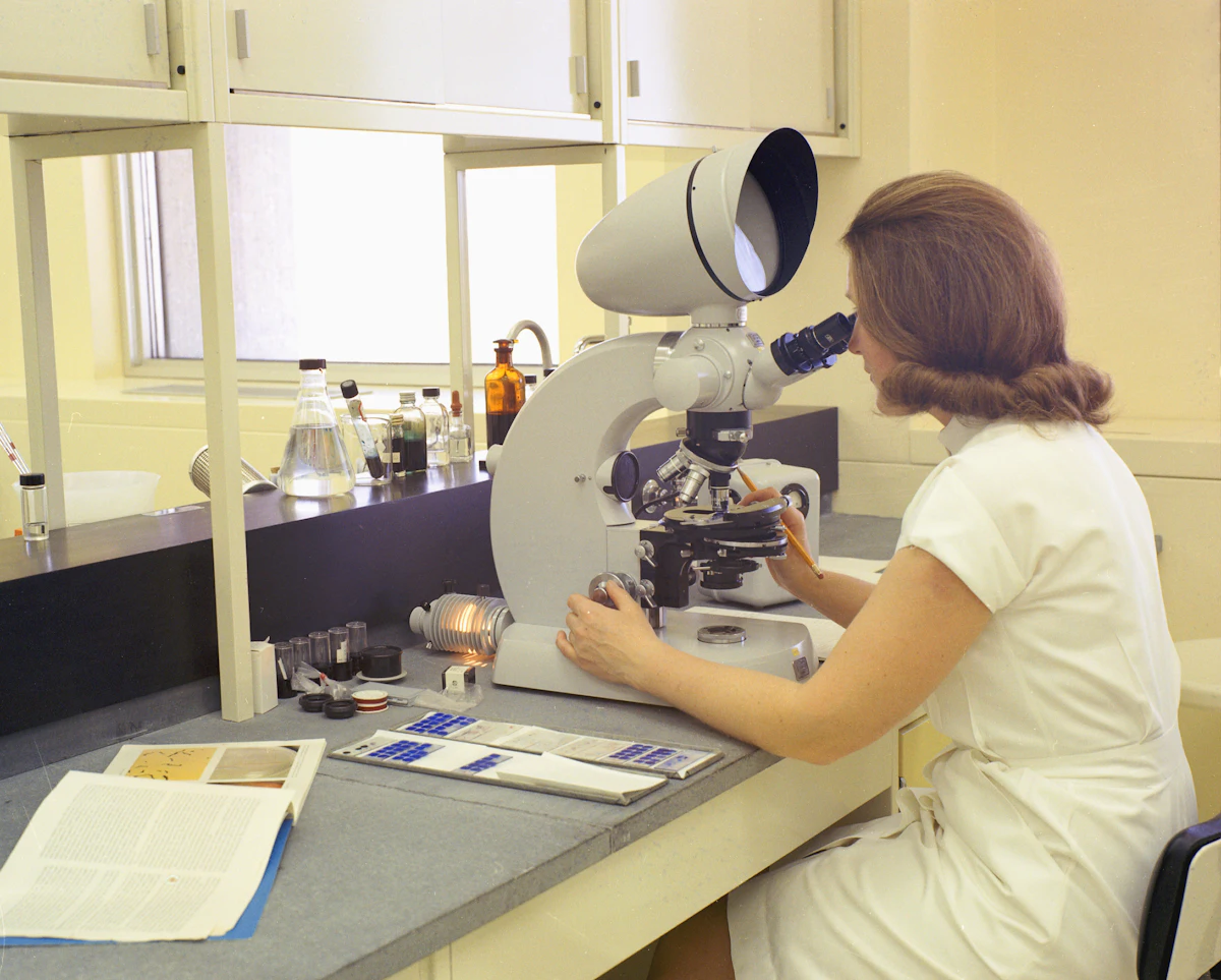 Laboratory analyst using a microscope