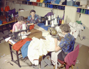 Visitors enjoying a lively sewing workshop event surrounded by colorful fabrics.