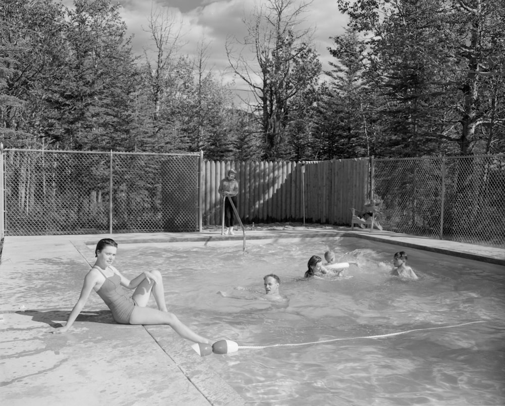 a woman in a bathing suit sitting in a pool